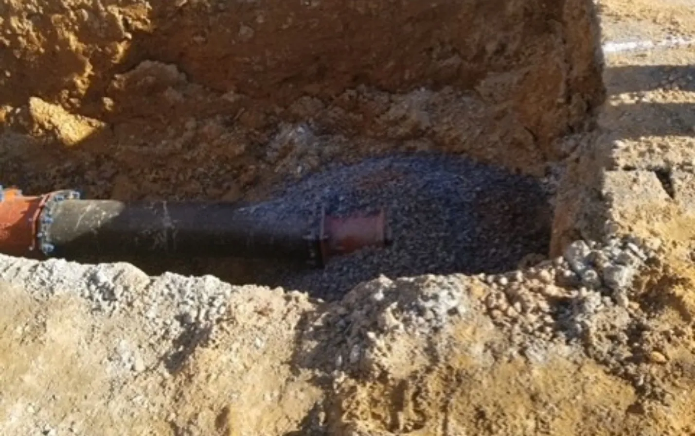 Excavated sanitary line undergoing pipe replacement